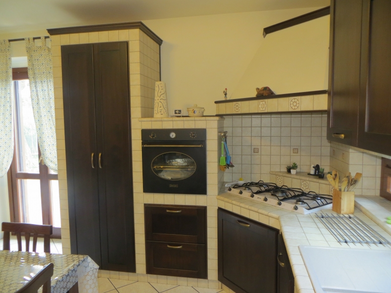  cucina realizzata completamente in legno rivestita di piastrelle, con finitura in rovere massello mordenzato 