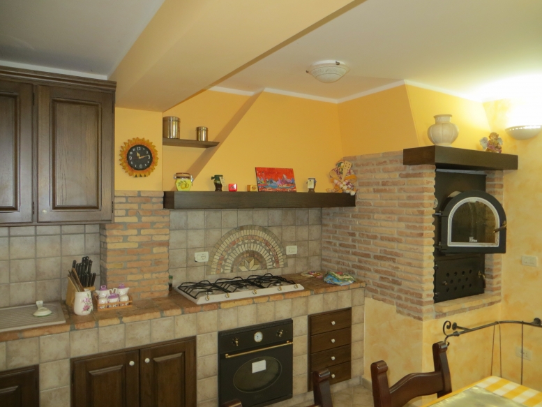  cucina realizzata completamente in legno rivestita di piastrelle, con finitura in rovere massello mordenzato 