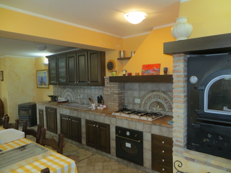  cucina realizzata completamente in legno rivestita di piastrelle, con finitura in rovere massello mordenzato 