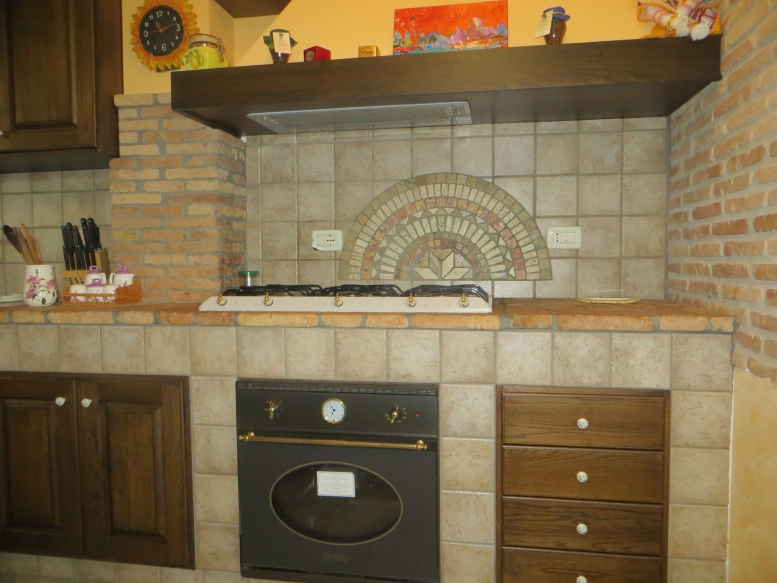  cucina realizzata completamente in legno rivestita di piastrelle, con finitura in rovere massello mordenzato 